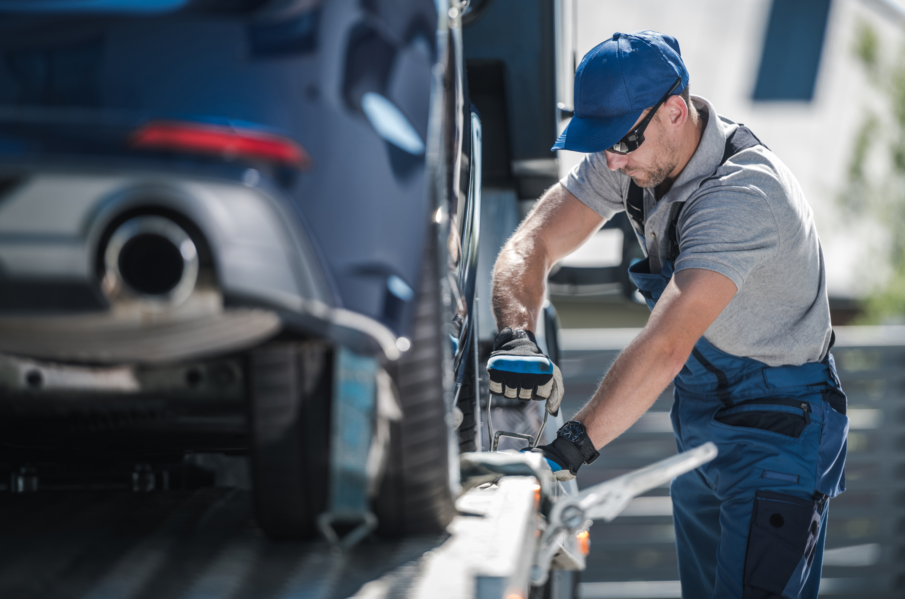 Tow Truck Driver Securing Vehicle on the Platform